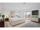 Spacious bedroom featuring stylish furnishings, balcony access, and a mounted television at 13193 Tollcross Way, Winter Garden, FL 34787