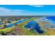 Aerial view of a canal that flows between a neighborhood and a vegetated marsh under a clear blue sky at 4321 Rummell Rd, St Cloud, FL 34769