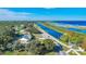 Aerial view of a waterfront home adjacent to a canal, and an adjacent neighborhood with a blue sky at 4321 Rummell Rd, Saint Cloud, FL 34769