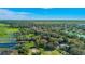 An aerial view displays a lakefront property with lush tree coverage under a clear, blue sky at 4321 Rummell Rd, St Cloud, FL 34769