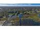 An aerial view showcasing waterfront marshland with a treed neighborhood in the distance under a blue sky at 4321 Rummell Rd, St Cloud, FL 34769