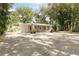 Exterior view of a mid-century ranch home boasting a brick facade and a large driveway at 4321 Rummell Rd, St Cloud, FL 34769