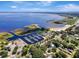 Wide aerial shot of a marina surrounded by trees with a lake in the distance, under a partially cloudy sky at 4321 Rummell Rd, St Cloud, FL 34769