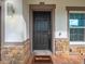 A welcoming front door with stylish stone accents and a 'Welcome' mat on a brick-paved porch at 5249 Villa Rosa Ave, St Cloud, FL 34771