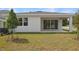 Backyard view of home with covered patio and sliding glass doors, plus newly planted trees at 1753 Carnelian St, Deland, FL 32720