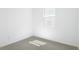 This bedroom is painted in a bright white, has an electrical outlet, a window, and carpet flooring at 1753 Carnelian St, Deland, FL 32720