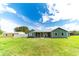 Inviting backyard with well-maintained lawn, a cozy porch with rocking chairs, and a charming home exterior at 4121 Albritton Rd, St Cloud, FL 34772
