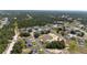 An aerial view shows the neighborhood and surrounding lush green landscape at 1415 Orlando Way, Kissimmee, FL 34759