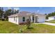 Attractive single-story home featuring a two-car garage, manicured lawn, and colorful flowerbeds in a bright setting at 1415 Orlando Way, Kissimmee, FL 34759