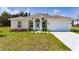 Charming single-story home with a well-manicured lawn, landscaped flower bed, and attached two-car garage at 1415 Orlando Way, Kissimmee, FL 34759