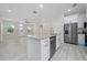 Open-concept kitchen featuring stainless steel appliances, granite island, and bright interior lighting at 1415 Orlando Way, Kissimmee, FL 34759