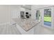 Bright kitchen featuring a granite-topped island, stainless steel appliances, and glass sliding doors at 1415 Orlando Way, Kissimmee, FL 34759