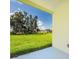 View from the patio overlooking the green lawn, blue sky, and scattered trees at 1415 Orlando Way, Kissimmee, FL 34759