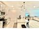 Modern kitchen featuring white cabinets, stainless steel appliances, a large island, and pendant lighting at 1608 Cross Prairie Pkwy, Kissimmee, FL 34744