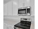 This modern kitchen showcases stainless steel appliances, sleek countertops, and stylish white cabinetry at 5410 Catmint Dr, Lake Hamilton, FL 33851