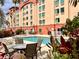 Relaxing outdoor pool area surrounded by lush greenery, lounge chairs and tables for lounging on a sunny day at 3000 Maingate Ln # 412, Kissimmee, FL 34747