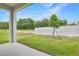 Backyard view with green grass, privacy fence, and covered patio at 4060 Bannock Ave, Tavares, FL 32778