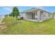 Backyard with green lawn, privacy fence, young trees, and covered patio at 4060 Bannock Ave, Tavares, FL 32778