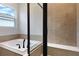 Bright bathroom featuring a soaking tub with tile surround and window at 4060 Bannock Ave, Tavares, FL 32778