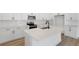 An island kitchen with modern appliances, white cabinets, and light countertops at 4060 Bannock Ave, Tavares, FL 32778