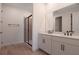 Bathroom features double sink vanity with white cabinets, black hardware, and glass-enclosed walk-in shower at 4064 Bannock Ave, Tavares, FL 32778