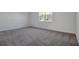 Bedroom featuring plush gray carpeting, white walls and trim, plus a window providing natural light at 4064 Bannock Ave, Tavares, FL 32778