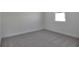 Bedroom featuring plush gray carpeting, white walls and trim, plus a window providing natural light at 4064 Bannock Ave, Tavares, FL 32778