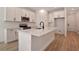 Modern kitchen features white cabinets, stainless steel appliances, and a large center island with sink and black faucet at 4064 Bannock Ave, Tavares, FL 32778