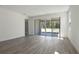 Spacious living room with wood-look tile floors and sliding glass doors to covered patio and green backyard at 4064 Bannock Ave, Tavares, FL 32778