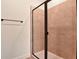 Walk-in shower with glass enclosure and pink tile surround with black hardware and showerhead at 4064 Bannock Ave, Tavares, FL 32778