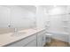 Bathroom featuring double sinks, white cabinets, light countertop, and a shower-tub combo at 5406 Catmint Dr, Lake Hamilton, FL 33851