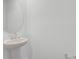 Stylish bathroom with a pedestal sink, round mirror, and clean, modern finishes at 5406 Catmint Dr, Lake Hamilton, FL 33851