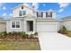 Charming two-story home with a gray stucco exterior, two car garage, and nicely landscaped front yard at 5406 Catmint Dr, Lake Hamilton, FL 33851