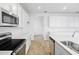 Full kitchen with white cabinets, stainless steel appliances, quartz countertops, and wood-look floors at 5406 Catmint Dr, Lake Hamilton, FL 33851