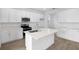 Modern kitchen featuring white cabinets, quartz countertops, stainless steel appliances, and an island with a sink at 5406 Catmint Dr, Lake Hamilton, FL 33851