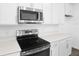 Close up of the stainless steel stove, microwave, and white quartz countertops in the modern kitchen at 5406 Catmint Dr, Lake Hamilton, FL 33851