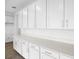Spacious kitchen with white cabinets, quartz countertops, stainless steel hardware, and wood-look flooring at 5406 Catmint Dr, Lake Hamilton, FL 33851