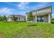 Spacious backyard featuring a well-manicured lawn, newly planted trees, and a covered patio of the two-story home at 1769 Carnelian St, Deland, FL 32720