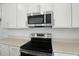 Stainless steel microwave and range oven with smooth, light countertops and white cabinets at 1769 Carnelian St, Deland, FL 32720