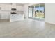 Open-concept living space with wood-look tile floors and sliding glass doors to the backyard at 1769 Carnelian St, Deland, FL 32720