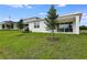 Backyard with green lawn and view of the house with patio and small trees at 1771 Carnelian St, Deland, FL 32720