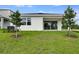 Backyard view of the home showing the yard, patio, and young trees at 1771 Carnelian St, Deland, FL 32720