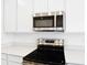 Close-up of the kitchen features stainless steel appliances and white countertops and white cabinetry at 1771 Carnelian St, Deland, FL 32720