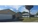 Tan house with white garage door and a palm tree in the front yard at 2118 Allspice Ave, Orlando, FL 32837