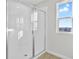 Bathroom shower with glass door features white tile surround and a window for natural light at 5418 Catmint Dr, Lake Hamilton, FL 33851