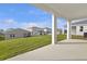 A covered patio offers an outdoor living space with a view of the yard and neighboring homes at 5418 Catmint Dr, Lake Hamilton, FL 33851