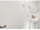 Stylish half-bathroom featuring a pedestal sink, round mirror, and bronze fixtures at 5418 Catmint Dr, Lake Hamilton, FL 33851