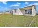 Backyard featuring a covered patio, sliding glass doors, newly planted tree, and fresh sod at 5422 Catmint Dr, Lake Hamilton, FL 33851