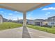 Covered patio with view of grassy backyard and neighboring homes under a blue sky at 5422 Catmint Dr, Lake Hamilton, FL 33851