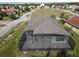 Aerial view of a home with a large screened-in lanai, set in a neighborhood with green spaces at 3907 Golden Knot Dr, Kissimmee, FL 34746